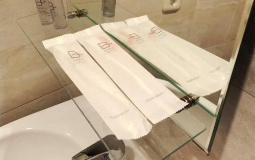 two white towels on a glass counter in a bathroom at Baga Resort Hotel in Lagudri