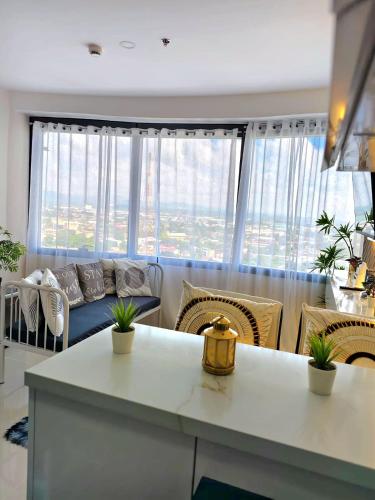 JTower Residences beside SM Jmall Mandaue في مانداوي سيتي: غرفة معيشة مع أريكة ونافذة كبيرة