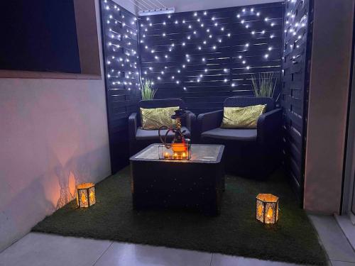 a patio with a table and chairs and lights at La Gold Room jacuzzi et sauna in Perpignan
