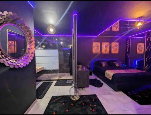 a purple bedroom with a bed and a mirror at La Gold Room jacuzzi et sauna in Perpignan