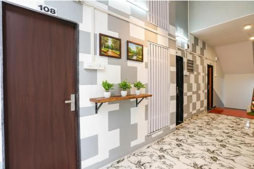 a corridor of a building with a door and plants at FabHotel Saroj Inn - Mumbai Naka in Nashik