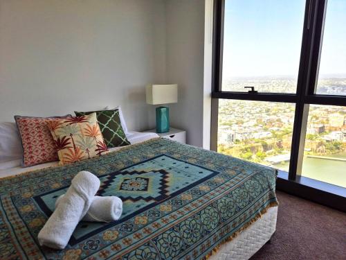 una camera da letto con un letto e un asciugamano sopra di Arabian Nights-Level 60-Meriton Suites- Free Parking a Brisbane