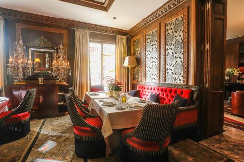 a dining room with a table and red chairs at Hôtel particulier Le DOGE - Relais & Châteaux in Casablanca