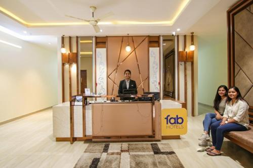 a man and two women sitting at a podium in a lobby at FabHotel K9 Regency in Dorāha