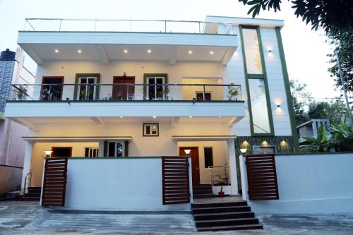 a large white house with a balcony at Go COOL-IN in Yercaud