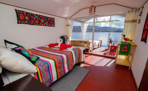 a bedroom with a bed and a balcony on a boat at Sol del Titikaka Lodge in Puno