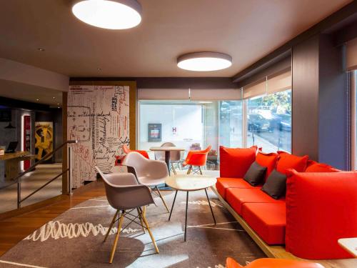 a living room with a red couch and a table at Hotel ibis Lisboa Liberdade in Lisbon