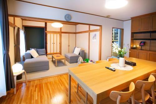 a kitchen and living room with a table and chairs at KazeVillaFurano in Furano