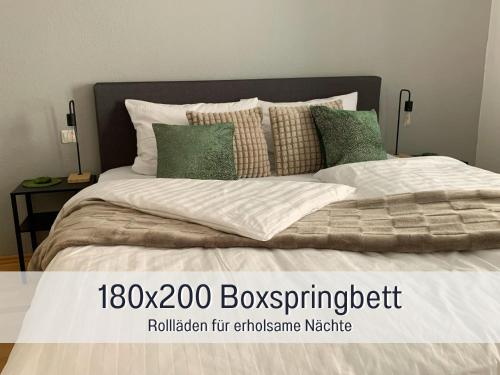 a bedroom with a large bed with green pillows at StayWest52 - Balkon, WLAN, Parkplatz in Ulm