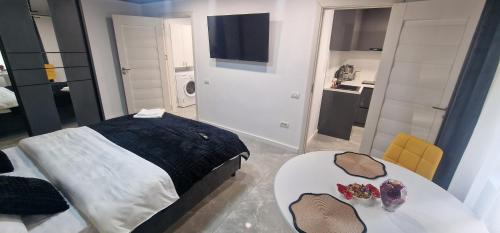 ein Schlafzimmer mit einem Bett und einem Tisch mit Gläsern darauf in der Unterkunft Studio Premium in Târgu Jiu