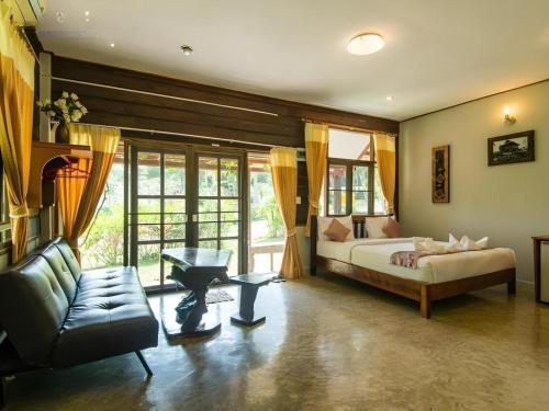 a large bedroom with a bed and a couch at De Bua Valley in Ban Kom