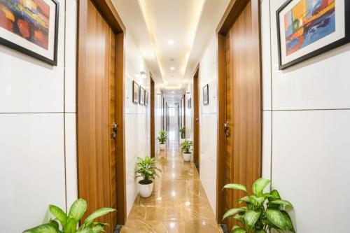 a corridor with potted plants in a hallway at FabHotel Shubham Inn - Nr Jain Mandir, Bhandup West in Mumbai