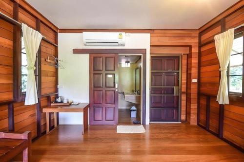 Ban KomにあるNicslongstay Hotelの壁と扉が木製の廊下