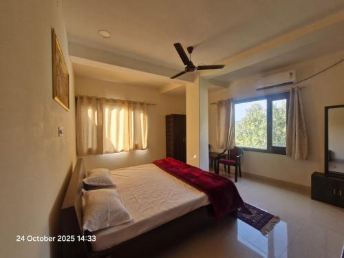 una camera da letto con un letto e un ventilatore a soffitto di Maharana Pratap Bhawan a Chamba