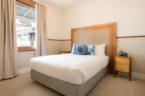a bedroom with a large white bed with blue pillows at 2 Houses, 1 Booking, Great Location in Launceston