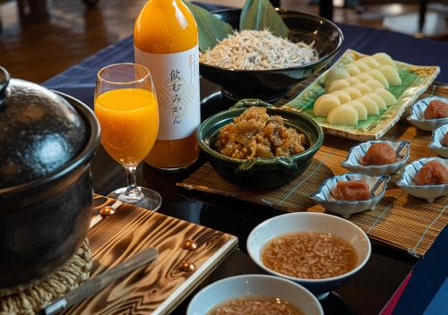 uma mesa coberta com tigelas de comida e uma garrafa de suco de laranja em Hotel Granvia Wakayama em Wakayama