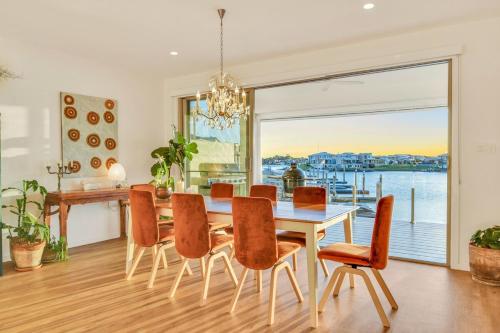 Un comedor con mesa y sillas y una gran ventana. en Waterfront-Bay View, en Port Macquarie