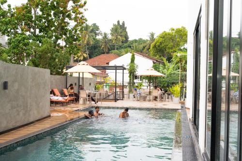 two people in a swimming pool at a hotel at Saninro Hotel - Ragama in Ragama