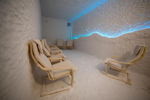 - une rangée de chaises dans une pièce avec des lumières bleues dans l'établissement Health & Wellness Center Energetikas, à Šventoji