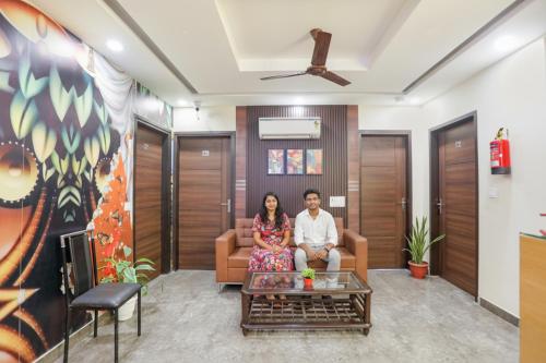 a man and a woman sitting on a couch in a living room at FabHotel Nirvana Residency in New Delhi
