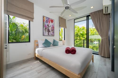 a bedroom with a bed with two red shoes on it at Luxury 5BR Pool Villa near Beach and Golf - Laguna Park 2 in Ban Phru Champa