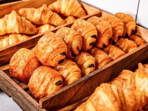 un montón de croissants en bandejas en una panadería en Ibis Jerez De La Frontera Cadiz, en Jerez de la Frontera