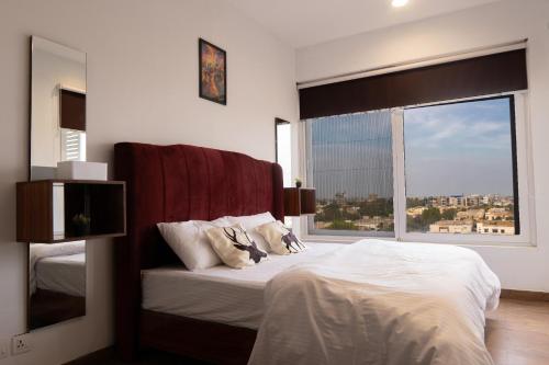 a bedroom with a bed and a large window at Penta Square Modern & Luxury Apartments City View DHA Lahore in Lahore