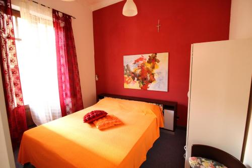 カステッランマーレ・デル・ゴルフォにあるBovio guest Houseの赤いベッドルーム(オレンジのシーツが入ったベッド付)