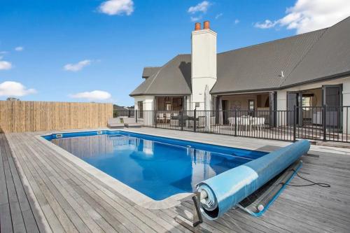 a swimming pool in front of a house at Luxury Mansion 7bdrm 6bth pool pizza ovn 25mns CBD in Silverdale