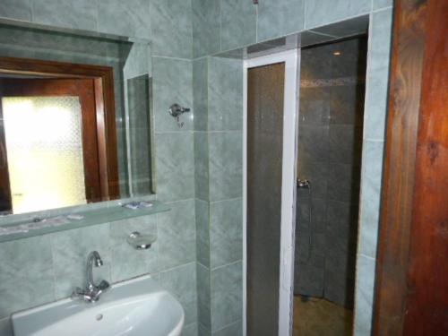 y baño con lavabo, espejo y ducha. en Guesthouse Peyna en Peyna