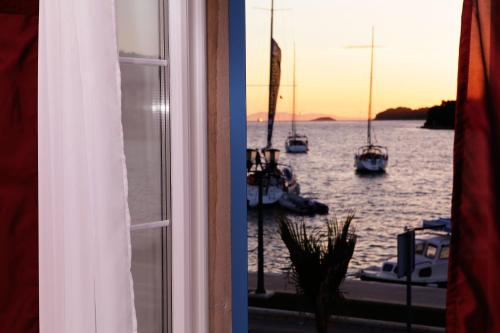 a window view of a harbor with boats in the water at Luxory D-Rooms in Vela Luka