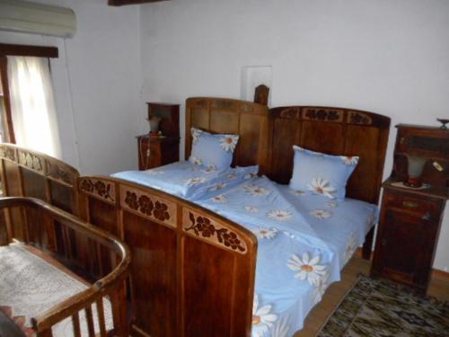 a bedroom with a large wooden bed with blue sheets at Guesthouse Peyna in Peyna