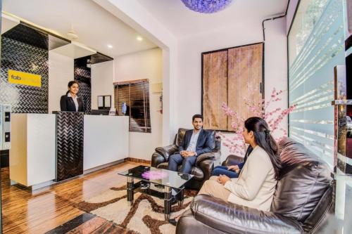 班加罗尔FabHotel Corporate Crown - Nr Jyoti Nivas University的一群人坐在大厅的皮椅上