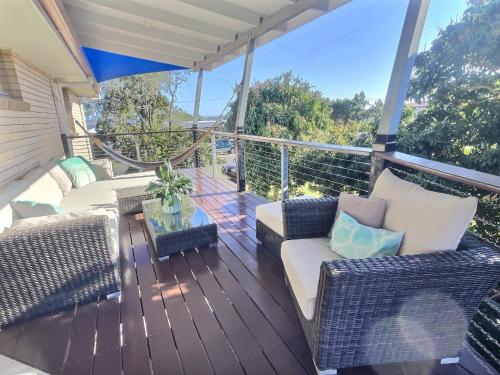 a deck with couches and a table on a balcony at Vista at Straddie View in Dunwich