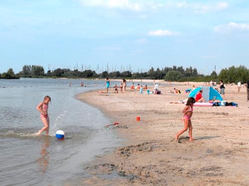 two girls playing in the water on a beach at BestMarine Waterchalets Flevo Marina in Lelystad