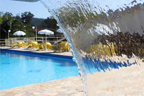 a water fountain in front of a swimming pool at Avenida Charme Hotel in Águas de São Pedro