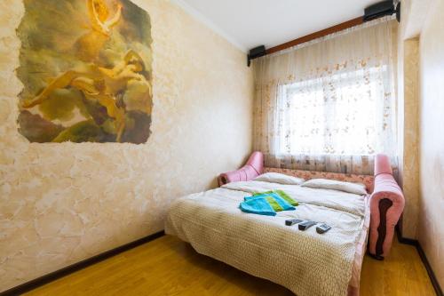モスクワにあるOn Bolshaya Tulskaya Apartmentのベッドルーム1室(壁に絵画が描かれたベッド1台付)