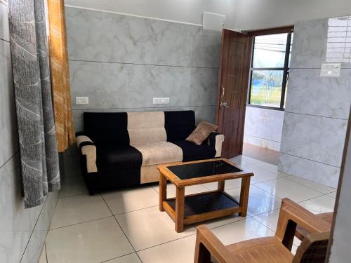 a living room with a couch and a coffee table at Shanti Nivas Homestays in Māvalli