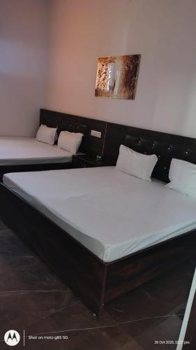 two beds are sitting in a room at hotel Neelgiri in Kichha