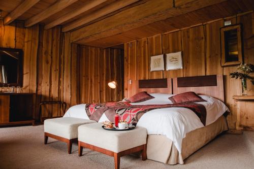 a bedroom with a bed and a table and chairs at Huilo Huilo Nothofagus Hotel & Spa in Huilo Huilo