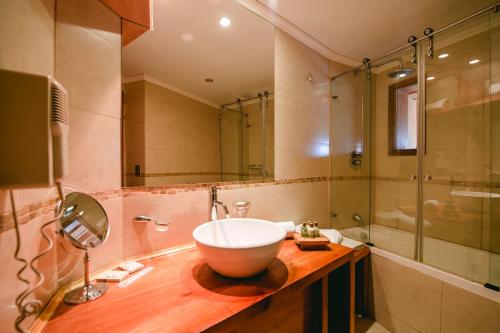a bathroom with a bowl sink and a shower at Huilo Huilo Nothofagus Hotel & Spa in Huilo Huilo
