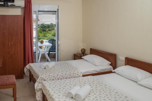 a hotel room with two beds and a balcony at Polymnia Studios in Olympic Beach