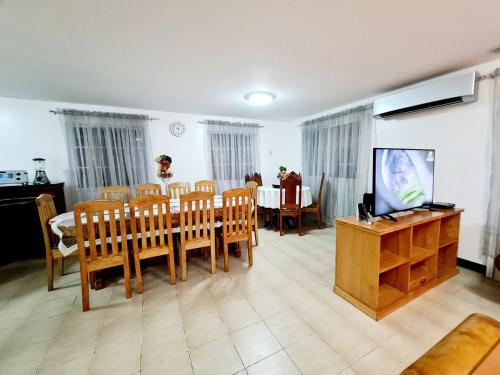 a dining room with a table and chairs and a television at Panglao Ramyer Villa 1 in Sampong