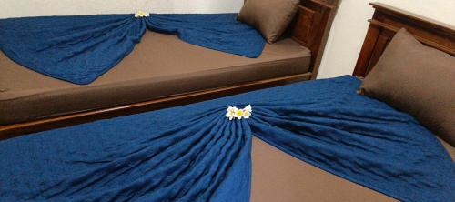 Una cama con sábanas azules y una manta azul. en marvin's guesthouse, en Lovina