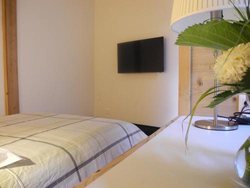 um quarto com uma cama e uma televisão na parede em L'Ours em Bischwiller