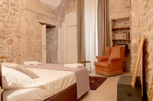 コンヴェルサーノにあるDei Balzi Dimore di Charmeのベッドルーム1室(ベッド1台、オレンジの椅子付)
