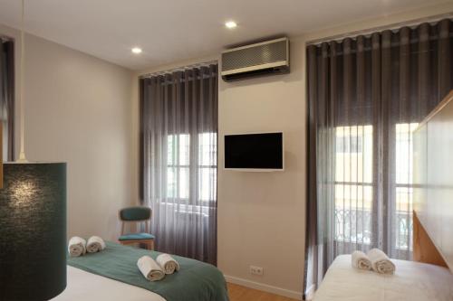 pokój hotelowy z dwoma łóżkami i telewizorem w obiekcie Boavista Guest House w Porto