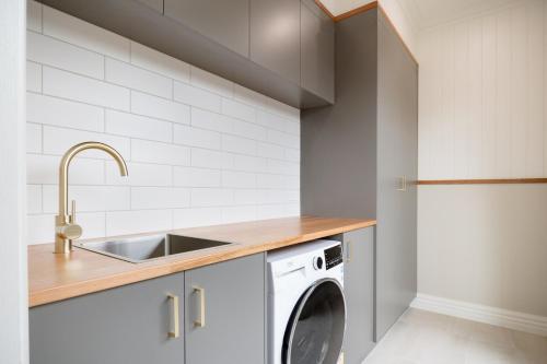 ローンセストンにあるPure Bliss - Comfort Delightのシンクと洗濯機付きのキッチン