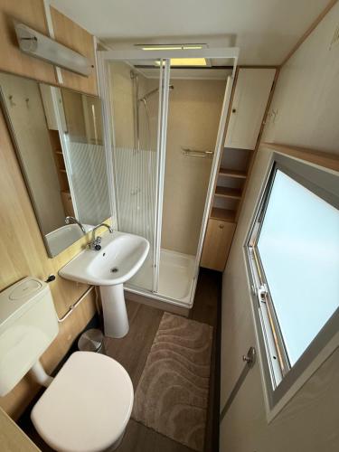 a small bathroom with a toilet and a sink at Camping Noetselerberg - Sallandse Stee - Stacaravan 5pers in Nijverdal