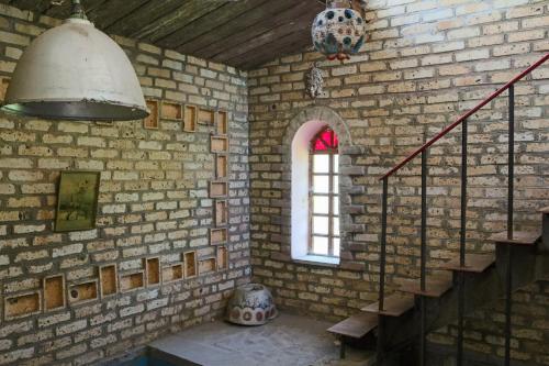 a brick room with a staircase and a window at Guest House Mary in Haghpat